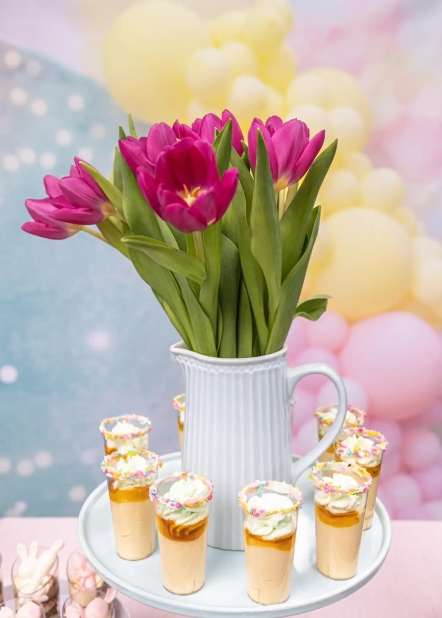 Pastel dessert shots display with tulips for baby shower