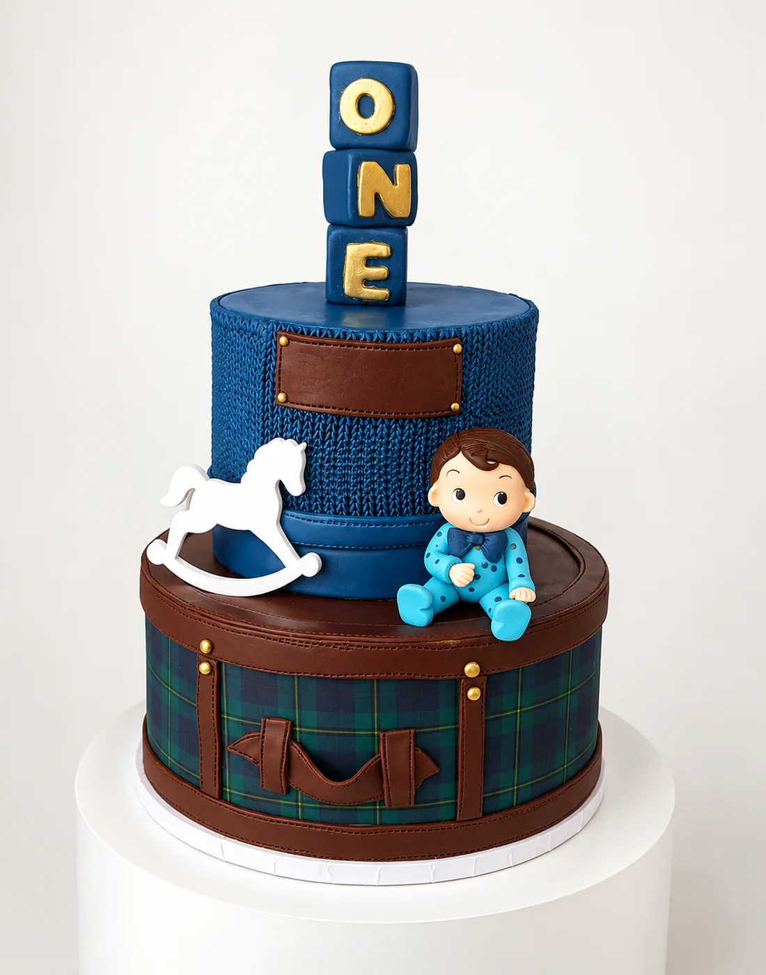 Two tier first birthday cake with knit texture, plaid base, rocking horse and ONE blocks