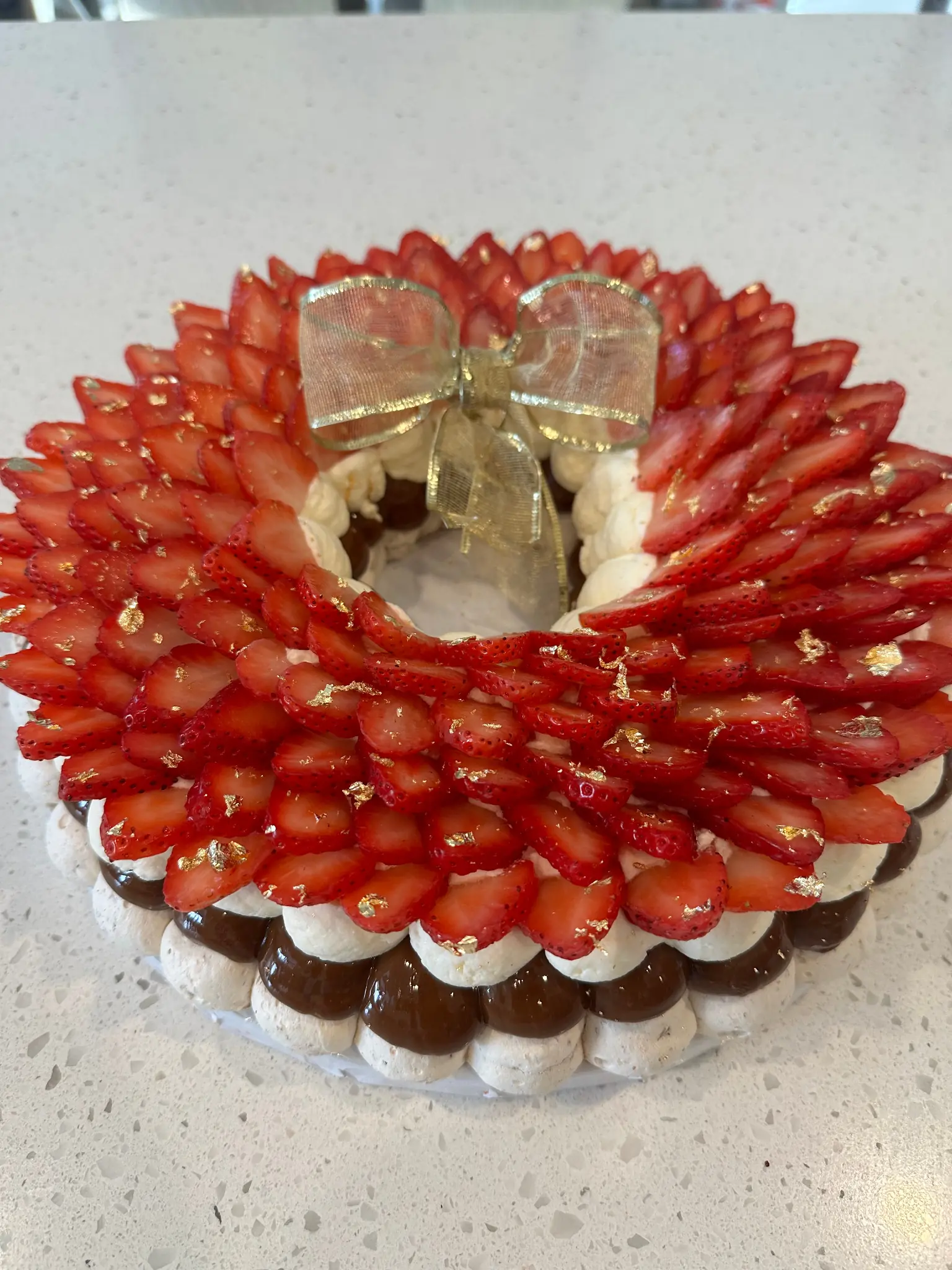Strawberry meringue wreath dessert with edible gold leaf
